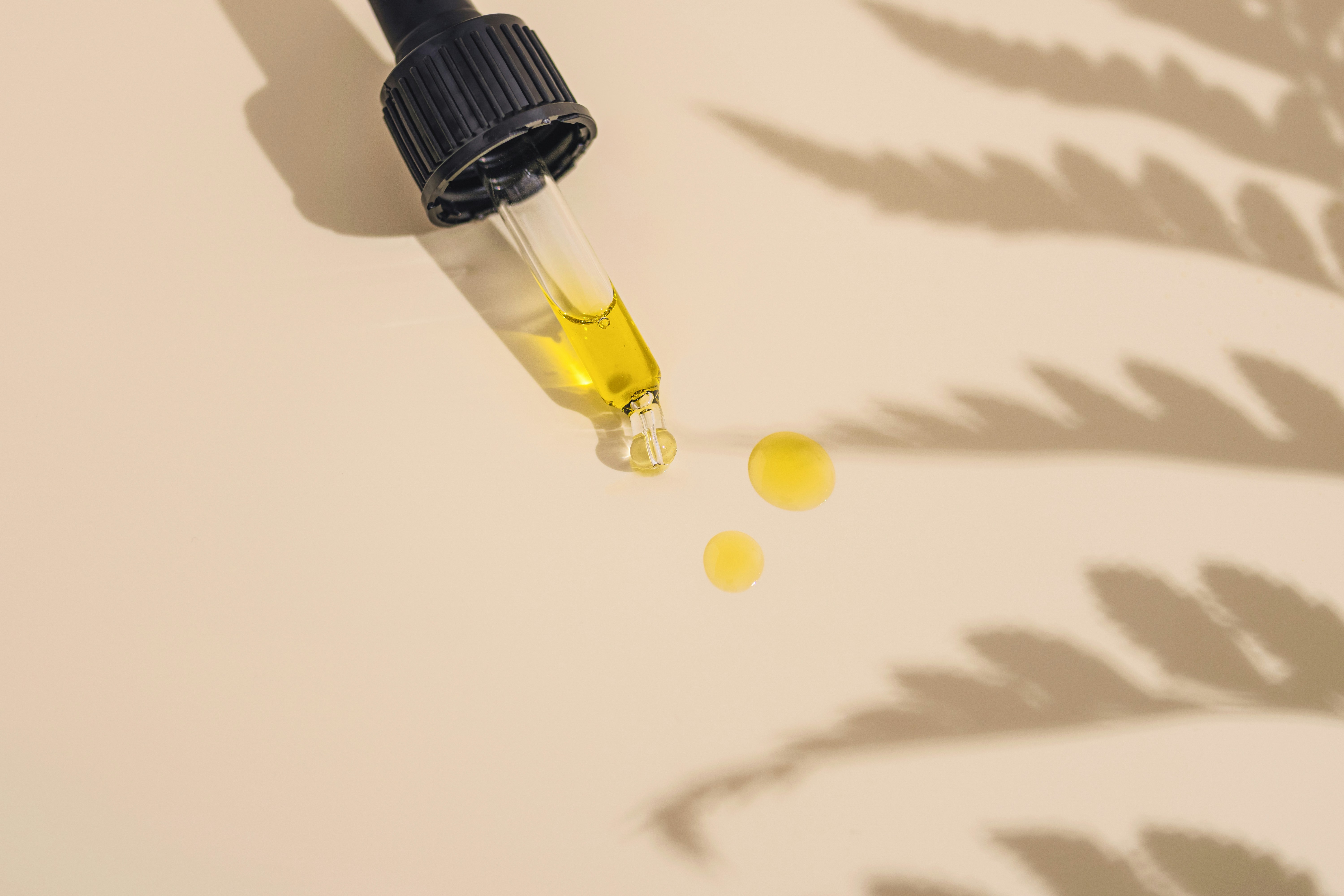 Golden skincare serum being dispensed from dropper bottle